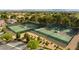 Aerial view of community tennis courts surrounded by trees and manicured landscaping, offering recreational opportunities at 5041 Portraits Pl, Las Vegas, NV 89149