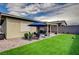 Expansive backyard boasts lush artificial turf, a covered patio, and serene outdoor seating at 505 Sterling Falls Ave, Henderson, NV 89011