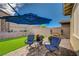 Relaxing backyard with artificial grass, patio seating, and decorative landscaping at 505 Sterling Falls Ave, Henderson, NV 89011