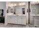 Elegant bathroom with double sinks, white cabinets, a glass-enclosed shower, and modern lighting at 505 Sterling Falls Ave, Henderson, NV 89011
