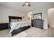 Comfortable bedroom featuring wood-look tile floors, dark wood furnishings, and access to the bathroom at 505 Sterling Falls Ave, Henderson, NV 89011