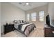 Bright bedroom with wood-look tile floors, multiple windows for ample natural light, and neutral decor at 505 Sterling Falls Ave, Henderson, NV 89011