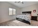 Comfortable bedroom with wood-look tile floors, large window, and a dark wood bed frame and side table at 505 Sterling Falls Ave, Henderson, NV 89011