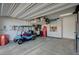 Well-organized garage with ample storage, including cabinets and overhead racks, plus a golf cart at 505 Sterling Falls Ave, Henderson, NV 89011