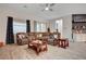 Comfortable living room with plush sectional sofa, decorative pillows, and stylish wood-look tile flooring at 505 Sterling Falls Ave, Henderson, NV 89011