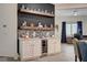 Custom bar featuring a wine fridge, custom backsplash, and floating shelves for decor at 505 Sterling Falls Ave, Henderson, NV 89011