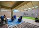 Inviting covered patio featuring comfortable seating, a ceiling fan, and a well-manicured artificial grass area at 505 Sterling Falls Ave, Henderson, NV 89011