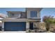 Charming two-story home with a blue garage door, well-manicured landscaping, and a large window at 5204 Padua Way, Las Vegas, NV 89107