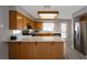 Well-lit kitchen featuring an island bar with oak cabinets, and stainless-steel appliances at 5204 Padua Way, Las Vegas, NV 89107