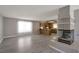 Spacious living room with wood laminate flooring, a fireplace, and a view into the adjacent kitchen at 5204 Padua Way, Las Vegas, NV 89107