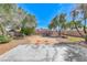 Spacious backyard featuring a concrete patio, mature trees, and block wall fencing at 5257 Sunbury Ave, Las Vegas, NV 89122