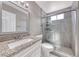 Bathroom featuring granite countertop, framed mirror and tiled walk-in shower with a glass door at 5257 Sunbury Ave, Las Vegas, NV 89122
