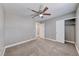 Neutral bedroom featuring a ceiling fan, carpet, baseboards and an open closet with a hanging rod at 5257 Sunbury Ave, Las Vegas, NV 89122