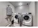 Laundry room featuring a washer and dryer and wall-mounted hot water heater at 5257 Sunbury Ave, Las Vegas, NV 89122