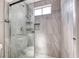 Modern tiled shower featuring a glass door and multiple storage shelves for toiletries at 5257 Sunbury Ave, Las Vegas, NV 89122