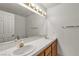 Bright bathroom featuring double sinks with wood cabinets and a large mirror with lighting at 5400 Paul Kurtz Way # 105, Las Vegas, NV 89108