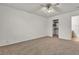 Carpeted bedroom featuring an open closet with shelves and a ceiling fan at 5400 Paul Kurtz Way # 105, Las Vegas, NV 89108