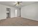 A carpeted bedroom with white walls, a ceiling fan and an open closet at 5400 Paul Kurtz Way # 105, Las Vegas, NV 89108