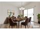 AI staged dining room with a dark wood table, seating for six, modern decor and natural light at 5400 Paul Kurtz Way # 105, Las Vegas, NV 89108