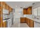 Charming kitchen showcasing wooden cabinets, white appliances, and tile floors at 5400 Paul Kurtz Way # 105, Las Vegas, NV 89108