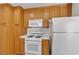 Modern kitchen featuring wooden cabinetry, a white microwave, and a range oven at 5400 Paul Kurtz Way # 105, Las Vegas, NV 89108