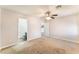 Spacious carpeted bedroom featuring ceiling fan, ensuite bathroom, and neutral color palette at 5524 La Pelusa St, North Las Vegas, NV 89031