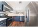 Open kitchen with stainless steel appliances, modern lighting, and wood look floors overlooking the living area at 5524 La Pelusa St, North Las Vegas, NV 89031