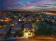 Night aerial view of a neighborhood showcasing a charming home with illuminated landscape at 556 Caribbean Palm Dr, Las Vegas, NV 89138