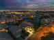Twilight aerial view of a residential neighborhood with city lights in the distance at 556 Caribbean Palm Dr, Las Vegas, NV 89138