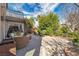 Lush backyard oasis featuring a covered patio with comfortable seating, mature trees, and decorative planters at 556 Caribbean Palm Dr, Las Vegas, NV 89138