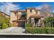 Charming two-story home showcasing a well-manicured lawn, mature landscaping, and a two-car garage at 556 Caribbean Palm Dr, Las Vegas, NV 89138