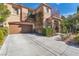 Inviting two-story home with a two-car garage and tidy landscaping enhancing its curb appeal at 556 Caribbean Palm Dr, Las Vegas, NV 89138