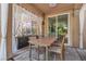 Relaxing covered patio with a dining set, sheer curtains for privacy, and access to both the backyard and the house at 556 Caribbean Palm Dr, Las Vegas, NV 89138