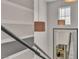 Modern stairwell featuring neutral tones, unique pendant lighting, and reflective mirror accent at 556 Caribbean Palm Dr, Las Vegas, NV 89138