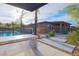 Stylish backyard featuring an outdoor kitchen, desert landscaping, and a clear view of the home's exterior at 6110 Pebble Glen Ct, Las Vegas, NV 89149