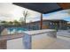Serene backyard showcasing a pool, modern outdoor kitchen, and manicured landscaping at 6110 Pebble Glen Ct, Las Vegas, NV 89149