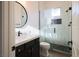 Stylish bathroom with sleek vanity, a modern round mirror, and a glass-enclosed shower with black hardware at 6110 Pebble Glen Ct, Las Vegas, NV 89149