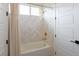 Bright bathroom featuring a tub and shower combo with herringbone tile and gold accents, complemented by white trim at 6110 Pebble Glen Ct, Las Vegas, NV 89149