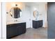Elegant bathroom with herringbone tile floors, double vanities, modern light fixtures and oval mirrors at 6110 Pebble Glen Ct, Las Vegas, NV 89149