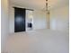 Bright bedroom with modern light fixture, barn door to bathroom, and neutral carpeting at 6110 Pebble Glen Ct, Las Vegas, NV 89149