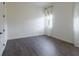 Minimalist bedroom with hardwood floors, white walls, and sheer curtains, creating a serene space at 6110 Pebble Glen Ct, Las Vegas, NV 89149