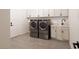 Laundry room with tile flooring, white cabinetry, and modern washer and dryer units at 6110 Pebble Glen Ct, Las Vegas, NV 89149