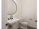Stylish powder room featuring a round mirror, modern sink, and fixtures next to toilet at 6110 Pebble Glen Ct, Las Vegas, NV 89149