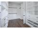 Bright walk-in closet with custom white shelving, drawers, and hanging rods for efficient storage solutions at 6110 Pebble Glen Ct, Las Vegas, NV 89149