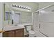 Neutral bathroom featuring a single vanity, shower-tub combo with sliding glass doors, and updated lighting fixtures at 6125 Desert Haven Rd, Las Vegas, NV 89130
