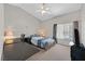 Comfortable bedroom features a ceiling fan, large window, and a functional desk area for work or study at 6125 Desert Haven Rd, Las Vegas, NV 89130