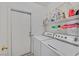 Well-lit laundry room with a washer, dryer, shelving, and storage baskets for laundry essentials at 6125 Desert Haven Rd, Las Vegas, NV 89130