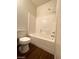 This bathroom features a shower-tub combo with white subway tile and wood-look flooring at 6316 Beige Bluff St # 201, North Las Vegas, NV 89081