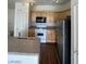 Updated kitchen features black microwave and stainless-steel refrigerator at 6316 Beige Bluff St # 201, North Las Vegas, NV 89081