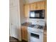 Kitchen featuring stainless steel appliances, wooden cabinets, and white gas stove at 6316 Beige Bluff St # 201, North Las Vegas, NV 89081
